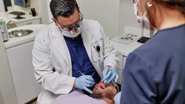 Dentista atendiendo a un paciente en clínica dental en Madrid